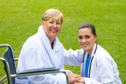 elderly woman on wheelchair with a nurse